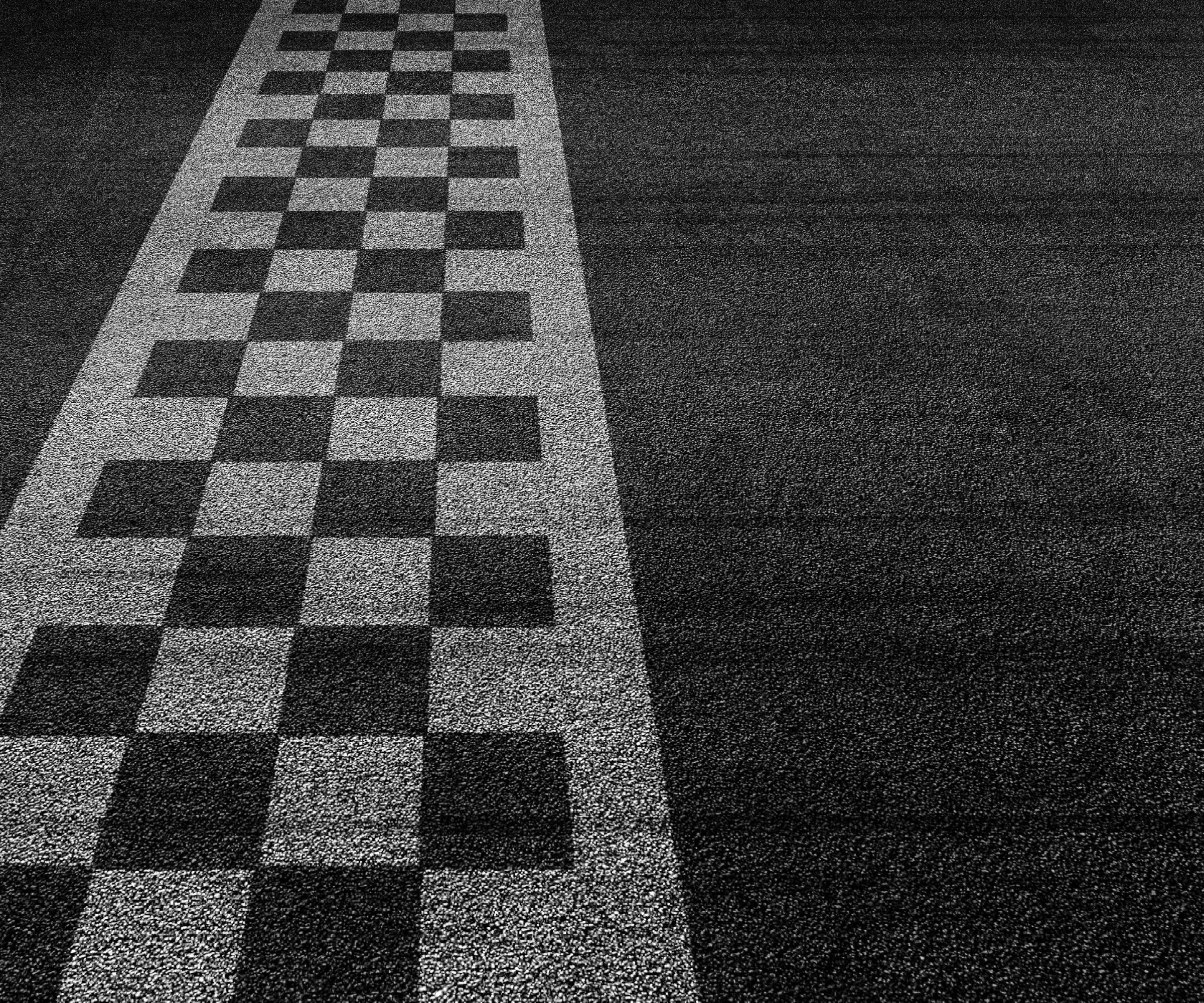 Checkered racing finish line on asphalt track