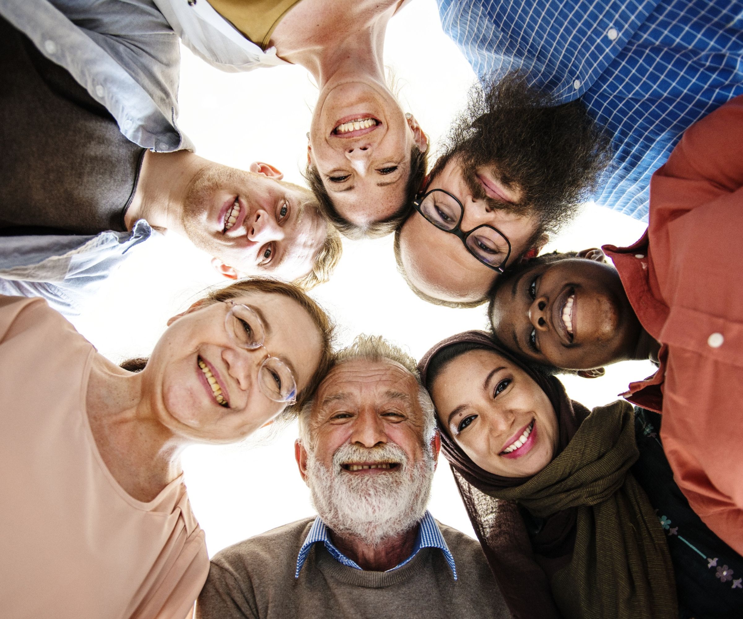 Diverse group smiling in circle above camera