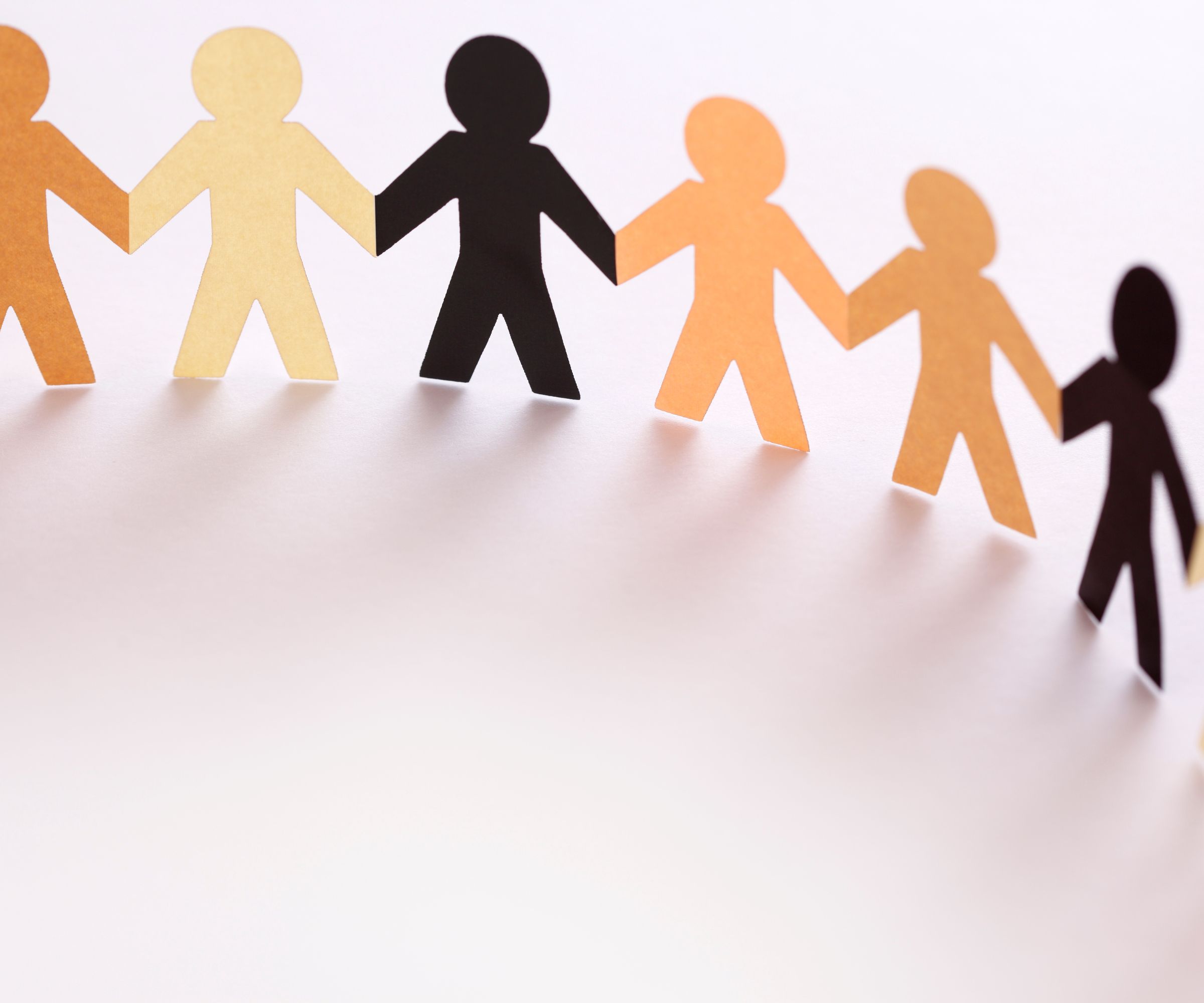 Paper cutout people holding hands in a row