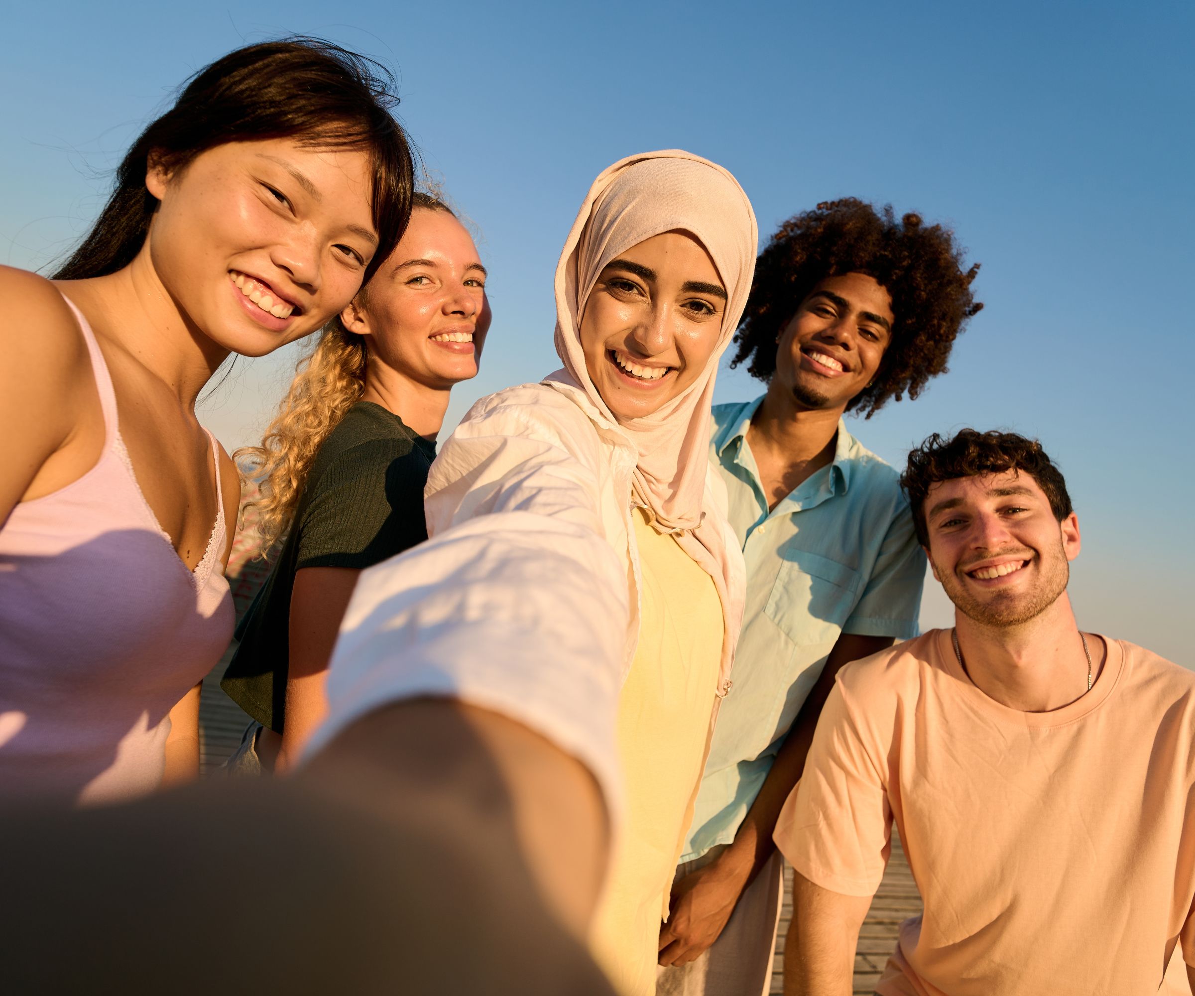 Five friends taking a sunset selfie outdoors