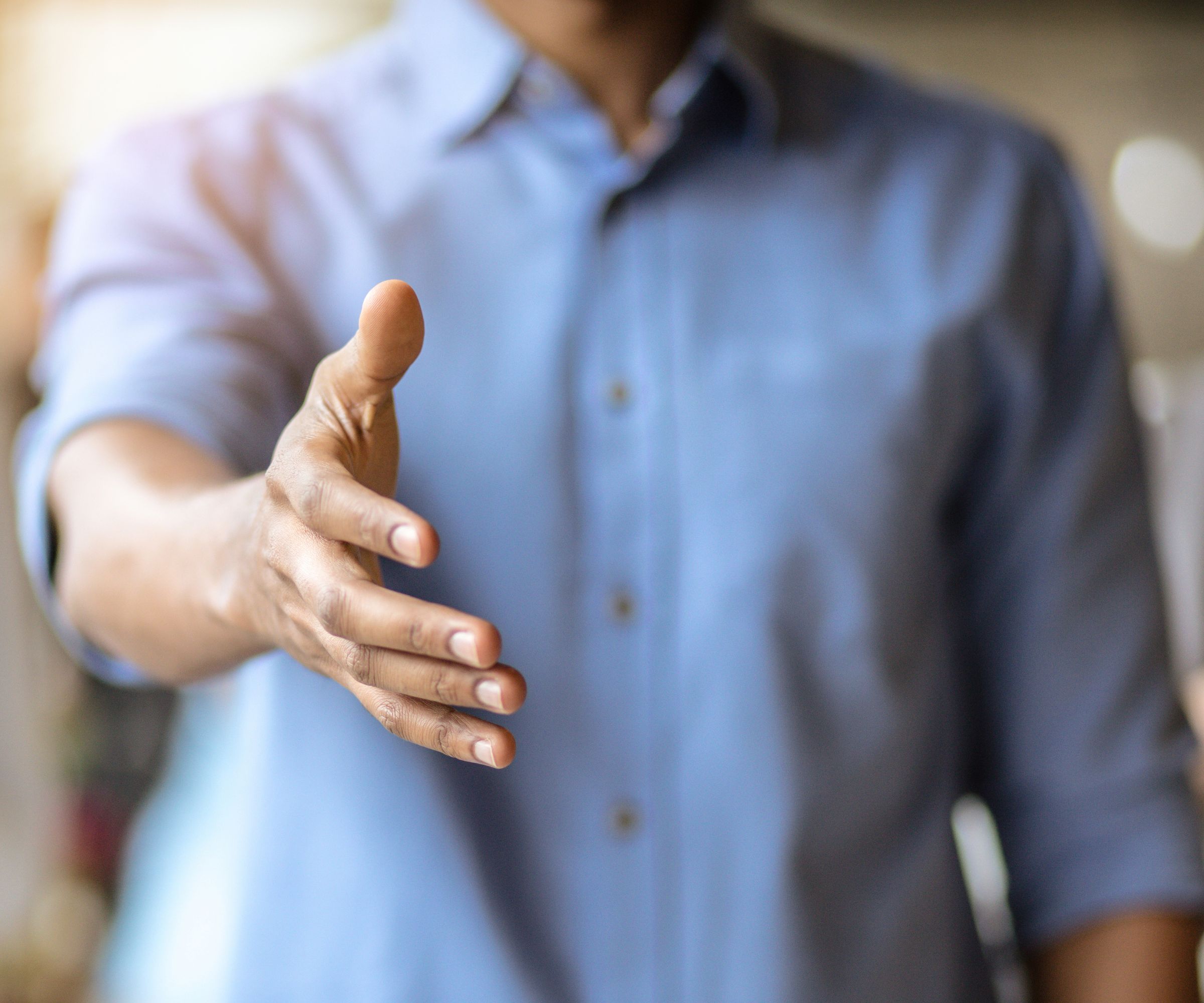 Person extending hand for handshake greeting
